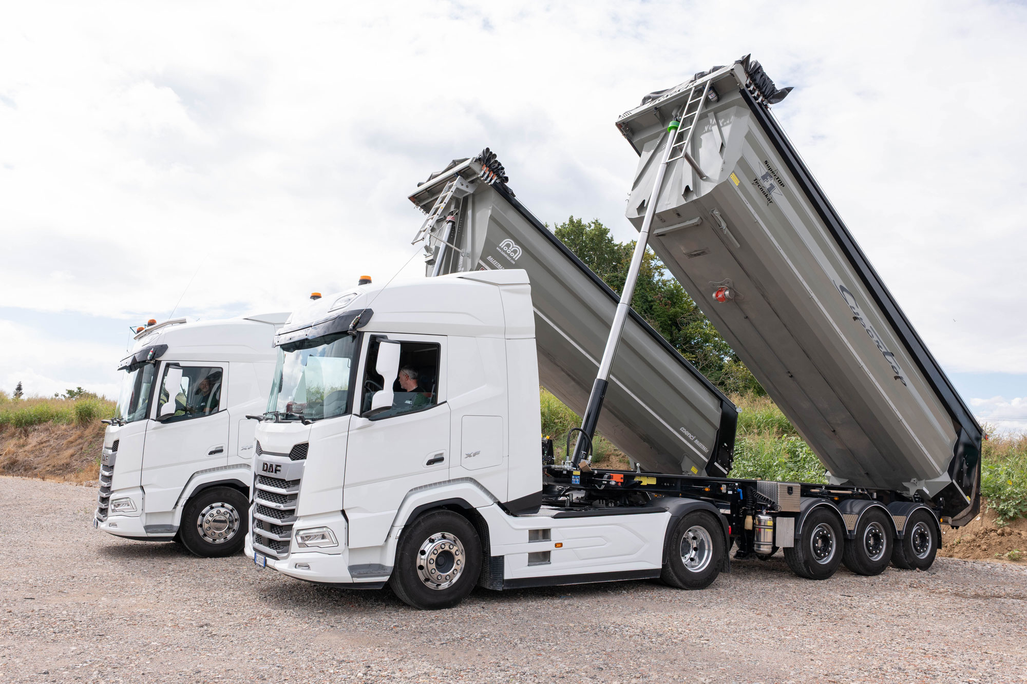 Due camion con vasche per trasporto di materiale inerte